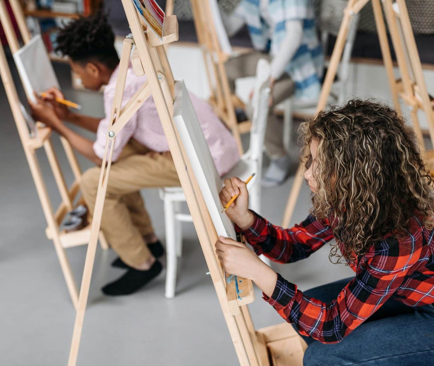 learners in a classroom drawing on easels