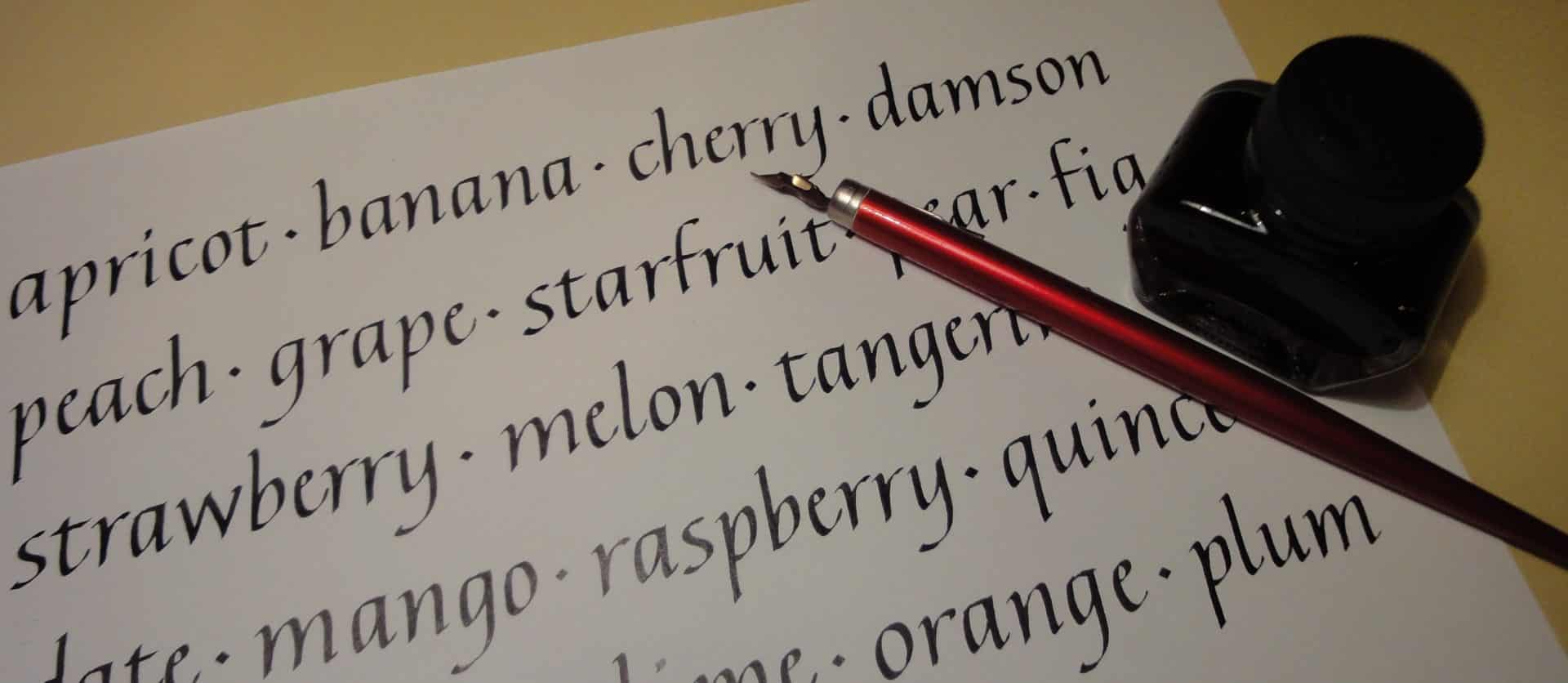 Calligraphic writing - names of fruit with a red calligraphy pen on top of the writing.