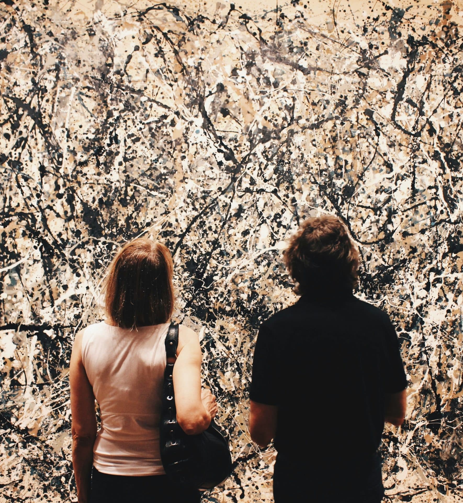 Two people looking at a large abstract painting