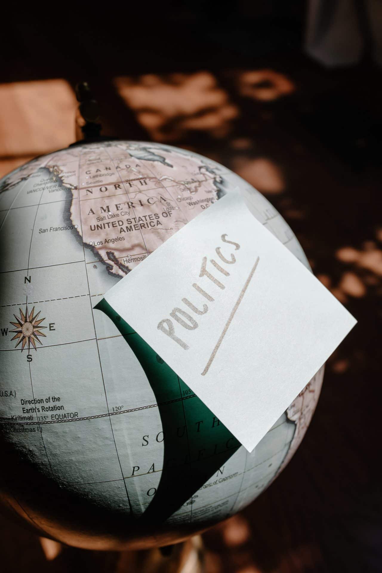 Image of a globe with Politics written on a post-it note