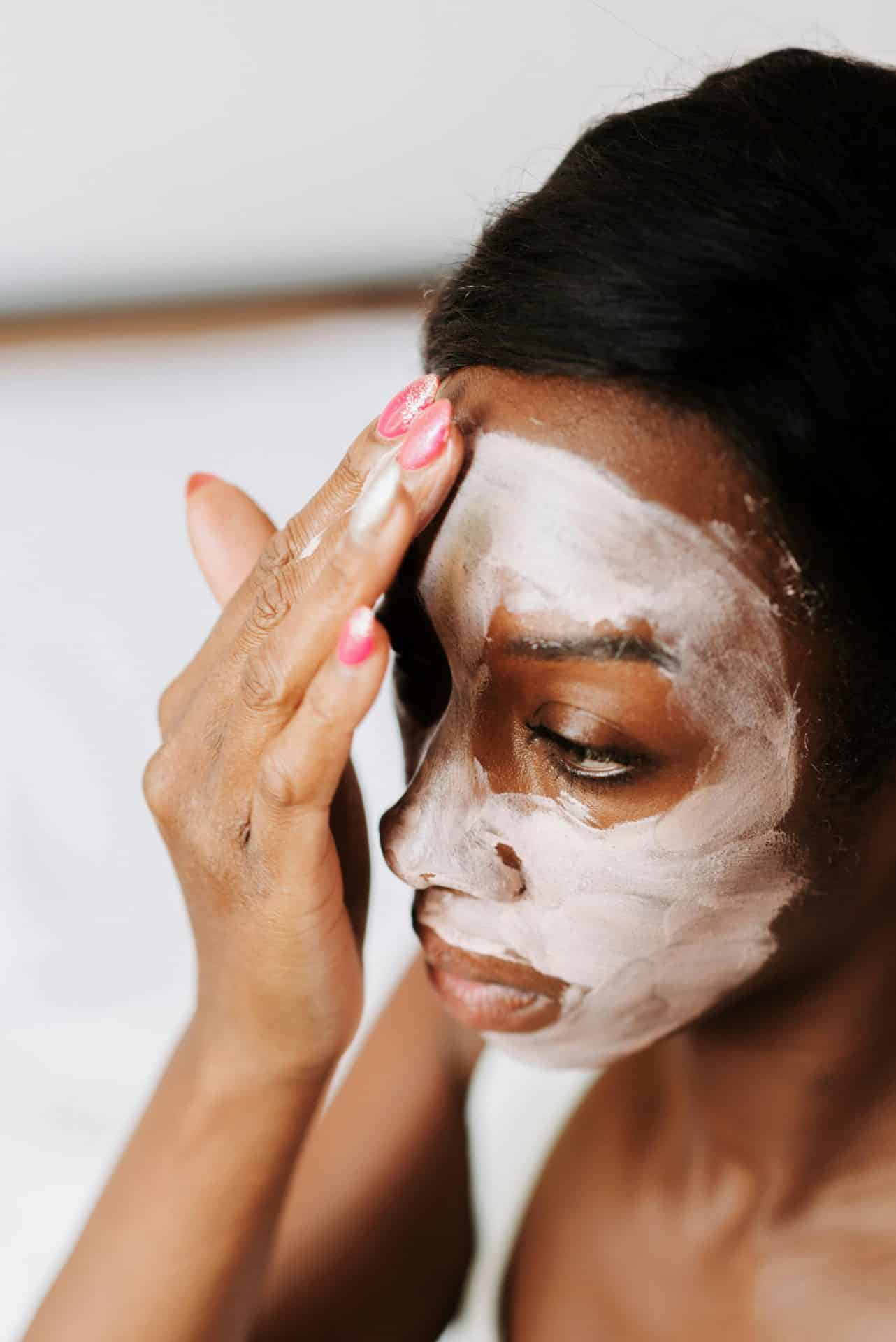 A lady applying a cosmetic face mask to her face